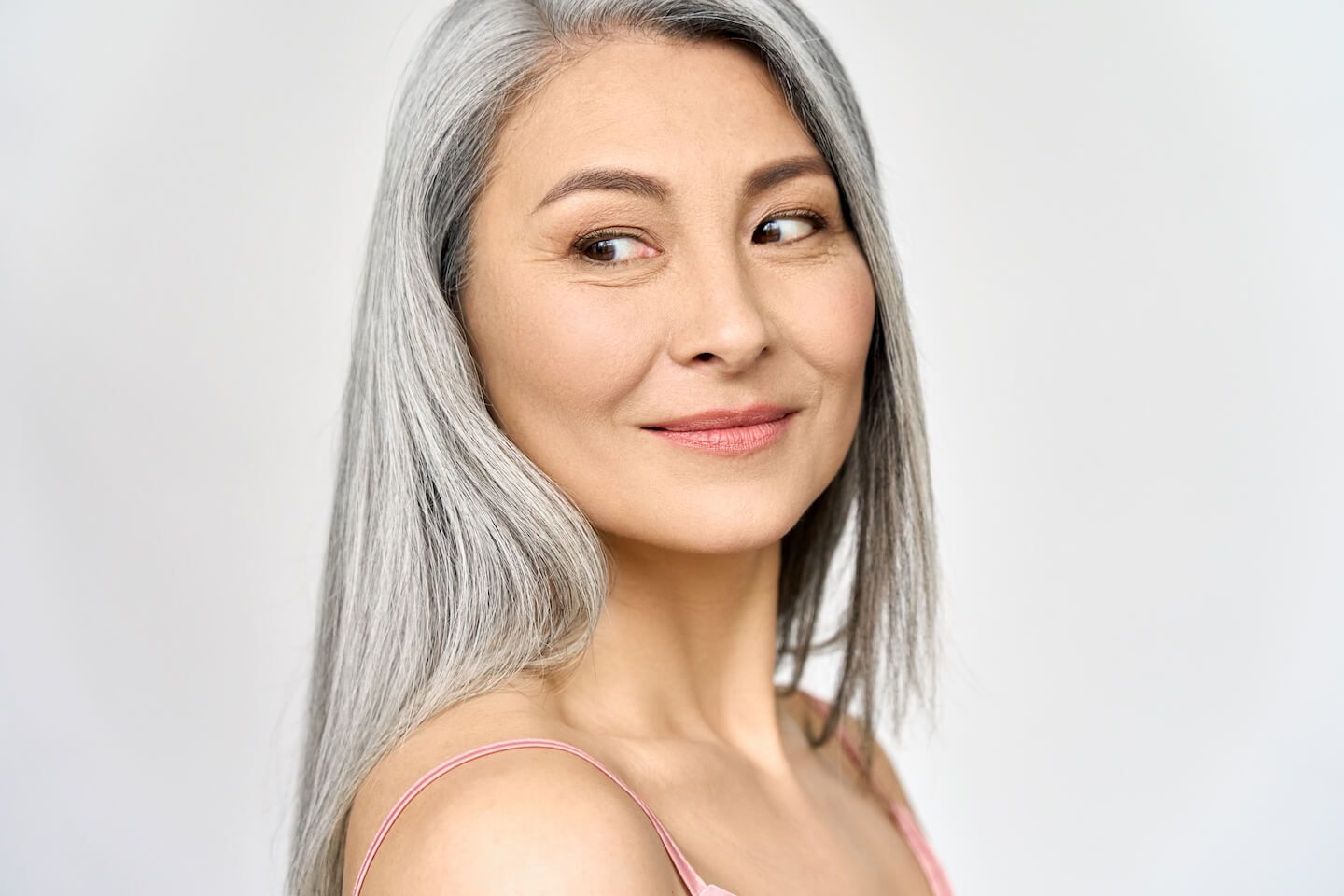 smiling asian woman with grey hair with Fine Lines Wrinkles on her face